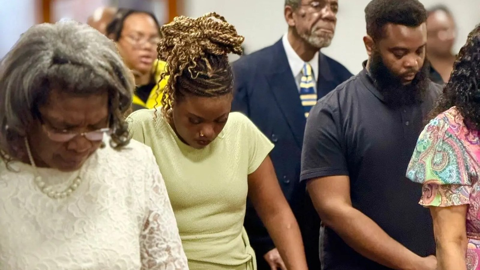 Unity Temple members standing together in prayer.
